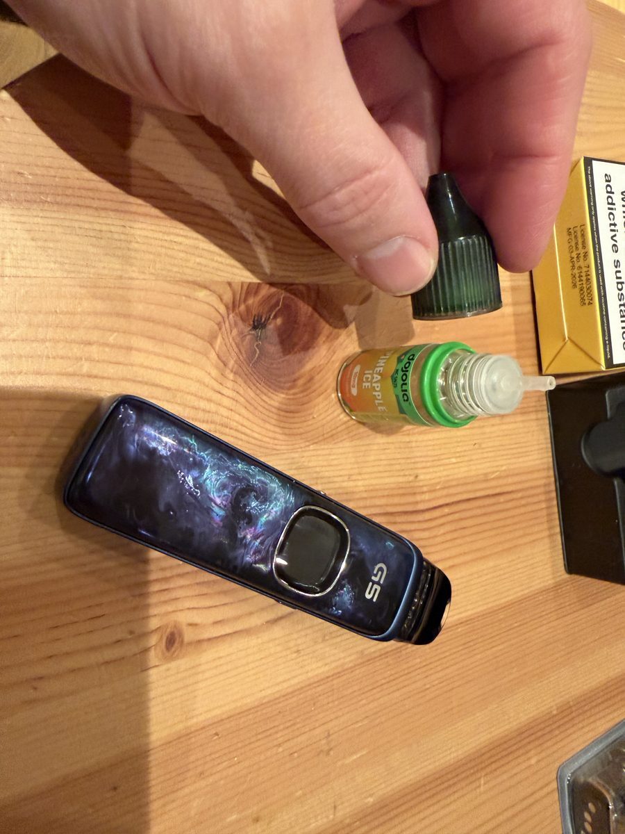 Refilling the Uwell Caliburn G5 pod through the spring-loaded fill port with Dojoliq Pineapple Ice nic salt