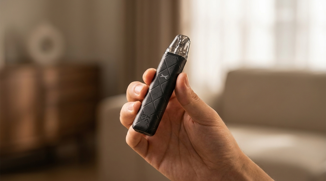 A hand holding a compact pod vape in a familiar hand-to-mouth grip