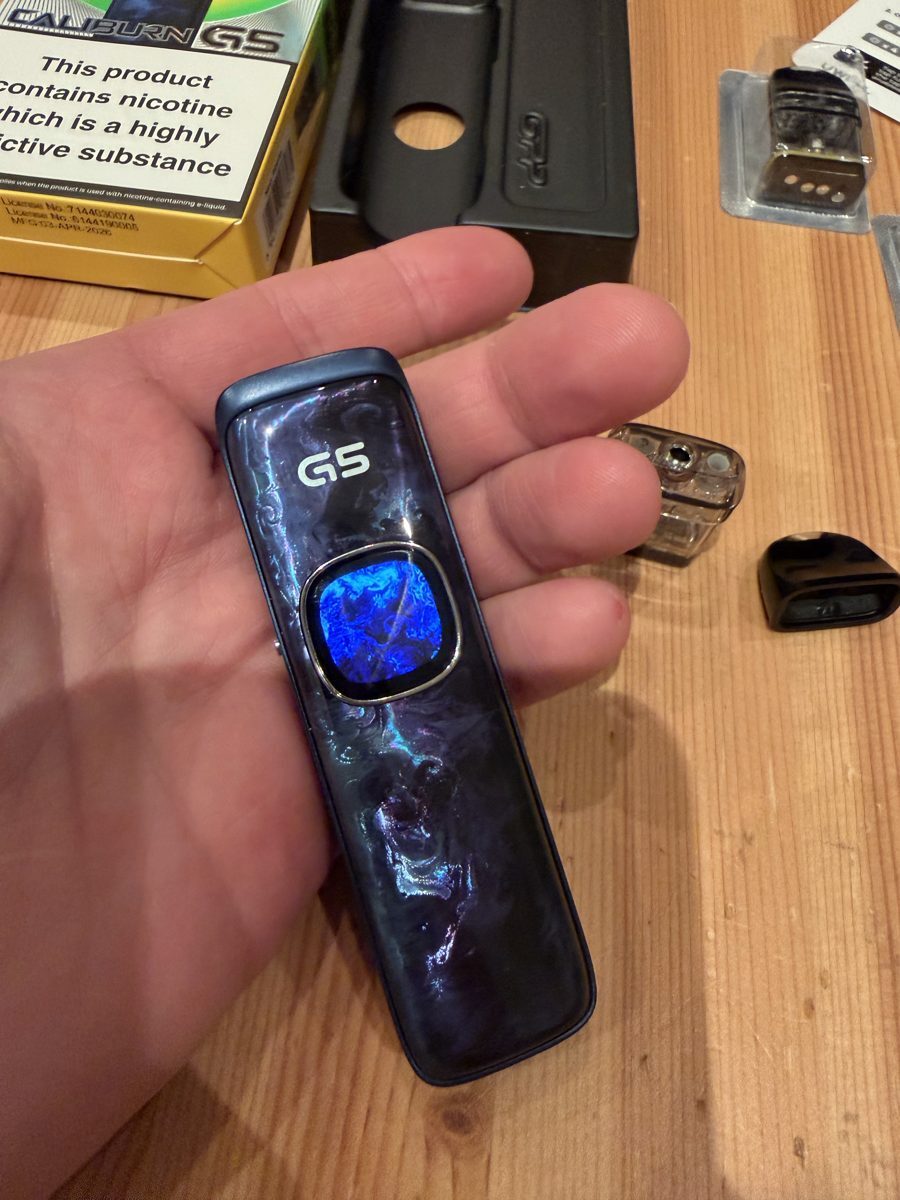 Uwell Caliburn G5 in hand with blue screen theme