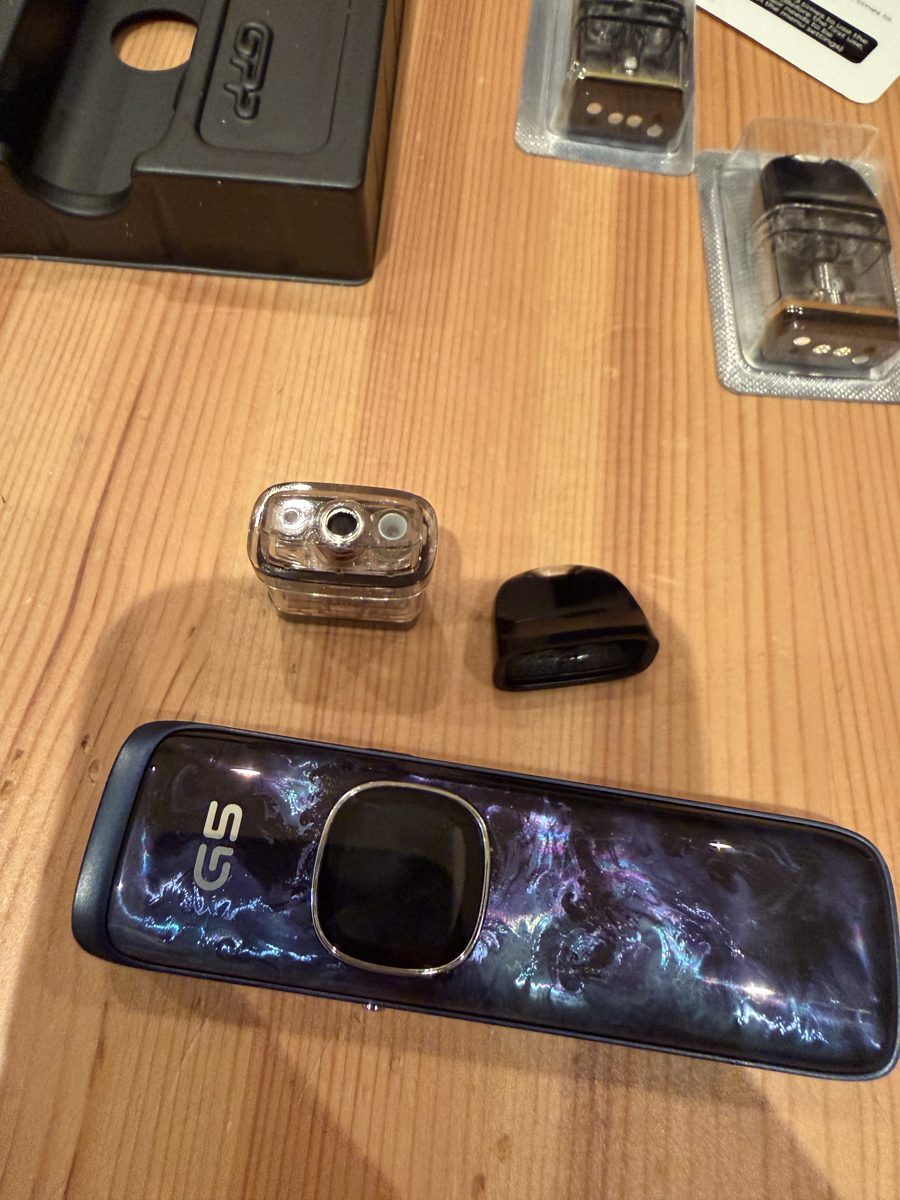 Uwell Caliburn G5 pod with snap-off top cap removed showing the spring-loaded fill ports