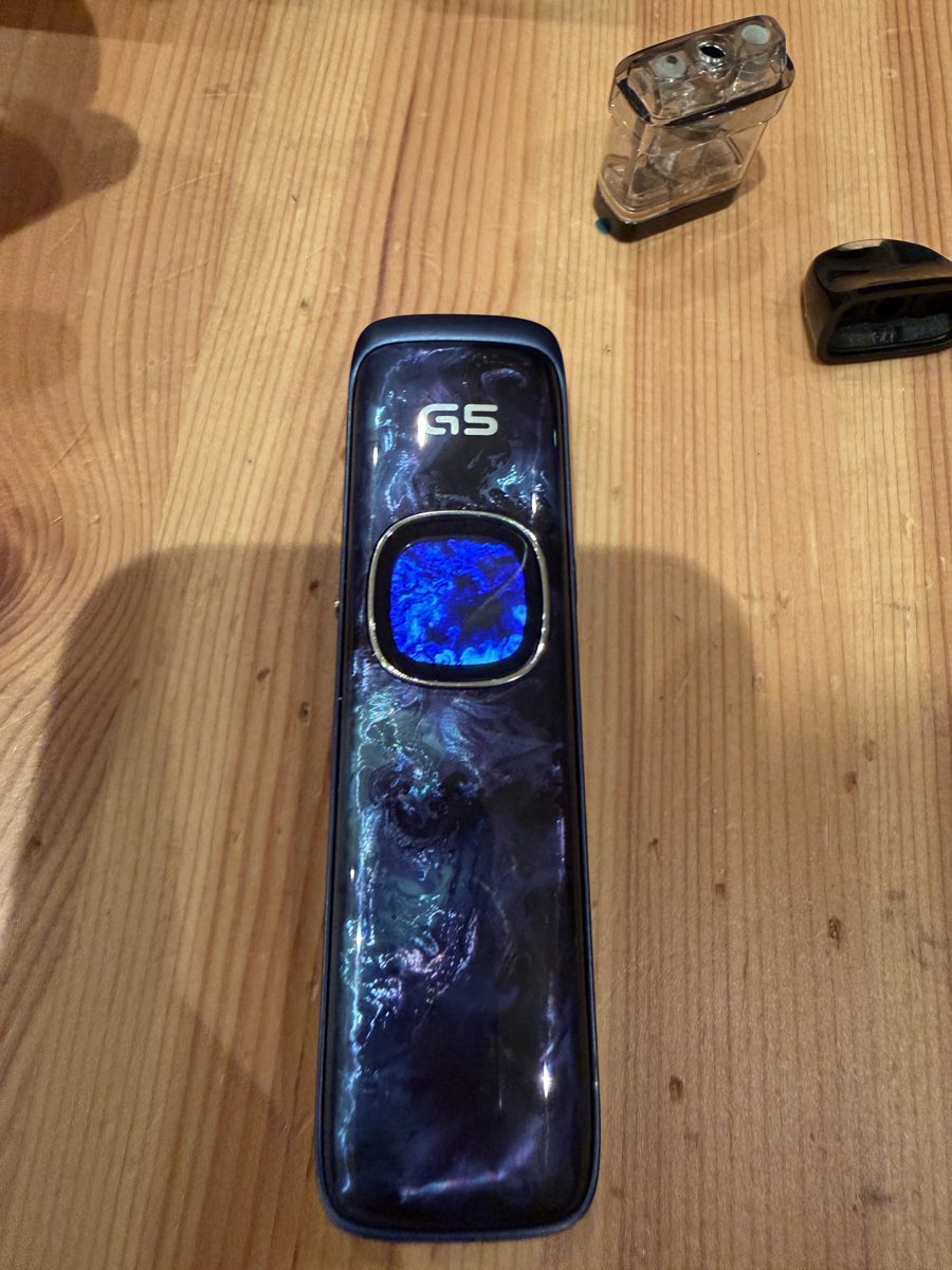 Uwell Caliburn G5 with colour-matched screen theme on a wooden table
