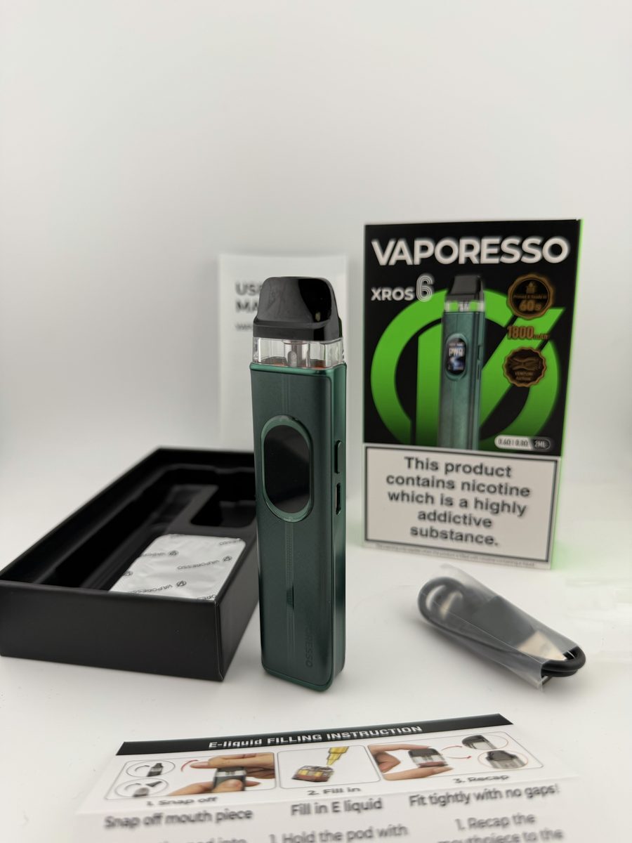Vaporesso XROS 6 box contents laid out with the retail box, tray, USB-C cable and e-liquid filling instruction card